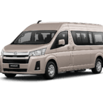 Toyota Hiace Premio Luxury coklat muda metallic tampak serong depan dan samping untuk layanan sewa Hiace Luxury Jakarta dengan driver profesional